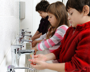 Children washing hands at communal sink